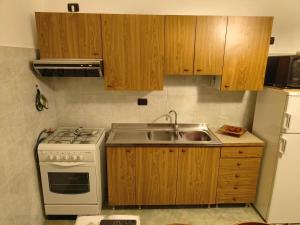 a kitchen with a white stove and a sink at Juppi Bed family in Sarnelli