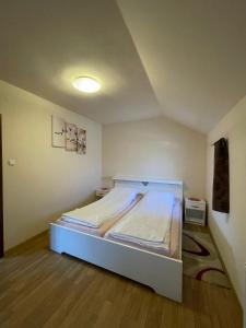 a bedroom with a white bed in a room at Adina Vendégház in Sîncraiu