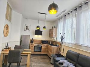 a kitchen with a couch and a table in a room at Métamorphose Champenoise in Épernay