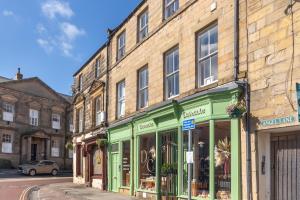 a building with green trim on a street at Alnwick Book Nook - dog friendly in Alnwick
