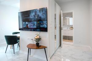 a living room with a table and a tv on the wall at Best Place in Jõhvi