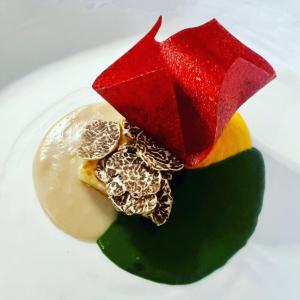 a white plate topped with a dessert with a red umbrella at La Locanda Del Capitano in Montone