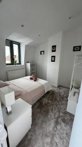 a white bedroom with a large bed and a window at Maison Cosy - Maison de Maitre in Saint-André
