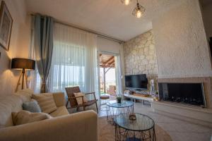 a living room with a couch and a fireplace at Thea Holiday Home in Nea Potidaea