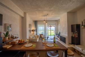 a living room with a large wooden table and chairs at Thea Holiday Home in Nea Potidaea