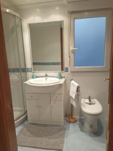 une salle de bain avec un lavabo, une douche et des toilettes dans l'établissement Almar, à Ribadeo