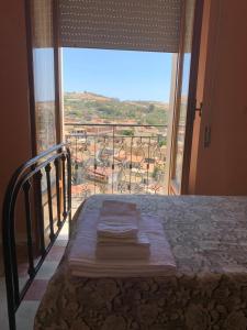 a bedroom with a bed and a large window at Guest house Natalina in Gioiosa Ionica