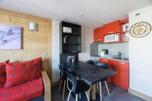 a small kitchen with a table and chairs in a room at Résidence Backgammon - LE BACKGAMMON MAE-3471 in Les Coches