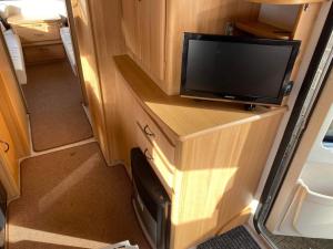 a television on a wooden cabinet in an rv at Hana Land in Qeparo