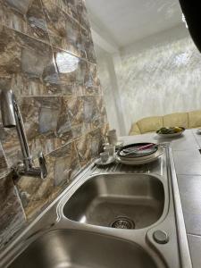 arsa taranga في داكار: مطبخ مع حوض وجدار حجري