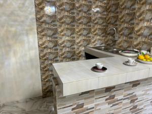 arsa taranga في داكار: طاولة مطبخ مع حوض وصحن من الفواكه