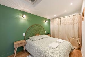 a bedroom with a bed and a green wall at L'Escapade Verdoyante - Confort, Élégance, Centrale in Cholet