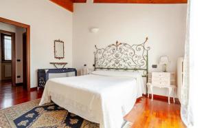 a bedroom with a large white bed and a table at Il nido della cicogna in Certosa di Pavia