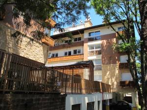um edifício de apartamentos com uma varanda e uma árvore em Temporada Gramado e Canela- Apartamento Centro Catedral em Canela