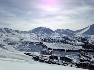 a town in the snow with mountains in the background at Résidence Les Hameaux Ii - Studio 3 pers - LES HAMEAUX 2 - 001H2 -PLAGNE VILLAGES MAE-1504 in Aime La Plagne +3 photos