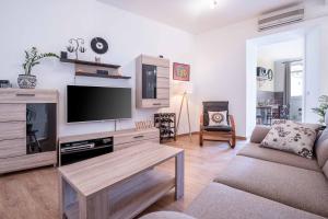 a living room with a tv and a couch at Porta Aurea sunny studio in Pula