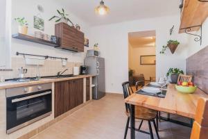 a kitchen with a wooden table and a dining room at Porta Aurea sunny studio in Pula