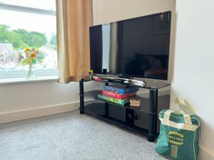 a flat screen tv sitting on a stand next to a window at The Courtyard, 4 - Bed, Sleeps 6, Pets Welcome in Ulverston