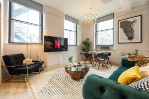 un salon avec un canapé vert et une table dans l'établissement Charlotte House Residence by COQOON, à Manchester