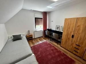 a bedroom with a bed and a desk with a red rug at Charming flat in Maribor