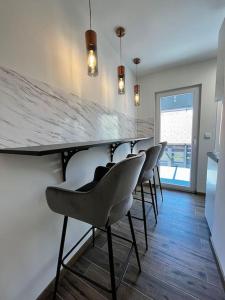 a bar with a row of chairs in a room at Charming flat in Maribor
