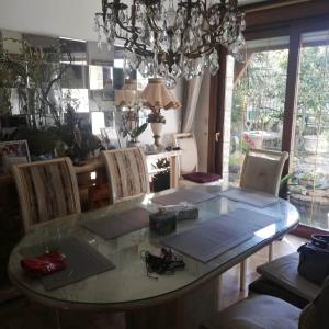a dining room with a glass table and chairs at Fastrentbnb Villepinte chambre cozy in Villepinte