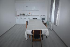 a kitchen with a table with chairs and white cabinets at Domacinstvo Jelkici in Zvornik