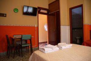 a room with a bed and a table and a television at Posada y Hosteria Sans Souci in Tanti