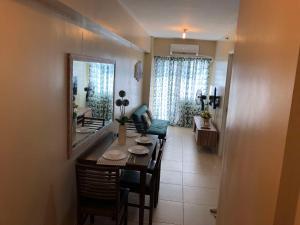 a dining room with a table and chairs and a living room at Majestic One Bedroom Condo Unit in Iloilo City