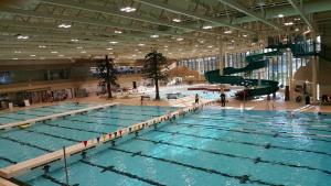 een groot zwembad met een glijbaan in een gebouw bij Hannah's Heavenly Home in Surrey