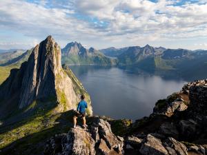 a man standing on top of a mountain overlooking a lake at Spacious Waterfront Gem - Panoramic View - Terrace in Fjordgård