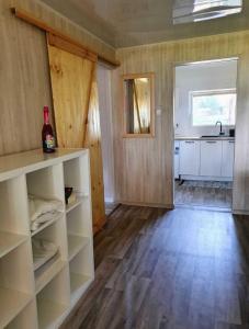 a kitchen with white shelves and a kitchen with a sink at Domek nad jeziorem przy lini brzegowej Górowychy, Pomorze in Gorowychy