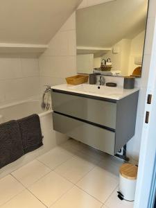 ein Badezimmer mit Waschbecken und Badewanne in der Unterkunft La jolie petite maison in Saint-André-les-Vergers