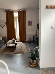 ein Wohnzimmer mit Sofa und Tisch in der Unterkunft La jolie petite maison in Saint-André-les-Vergers + 12 Fotos