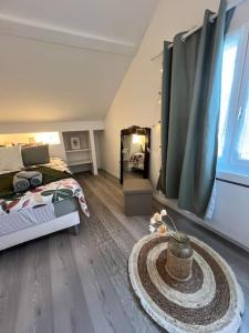 ein Schlafzimmer mit einem Bett und einem großen Fenster in der Unterkunft La jolie petite maison in Saint-André-les-Vergers