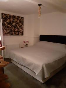 a bedroom with a white bed and a painting on the wall at Inspiro house4 in Scarborough