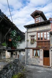 een oud stenen gebouw met potplanten erop bij Casa Rural Salices in Pola de Laviana