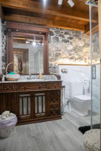 een badkamer met een wastafel, een toilet en een spiegel bij Casa Rural Salices in Pola de Laviana +46 foto's