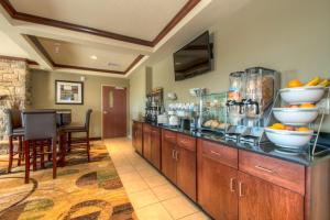 a kitchen with a counter with bowls of fruit on it at Cobblestone Inn & Suites - Holyoke in Holyoke