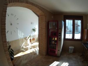 a room with a refrigerator and a clock on the wall at Hostal Los Escudos in Almagro