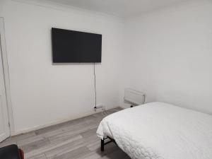 セールにあるRubies, Firs Road, Saleの白いベッドルーム(ベッド1台、薄型テレビ付)