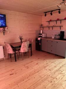 a dining room with a table and chairs and a television at EMKA Cottages Kazbegi in Kazbegi