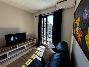 un soggiorno con un divano e una televisione di Apartamento em Itaipava a Petrópolis