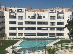 Un gran edificio con una piscina en frente. en Luxury apartment with pool in Estepona-centre, en Estepona