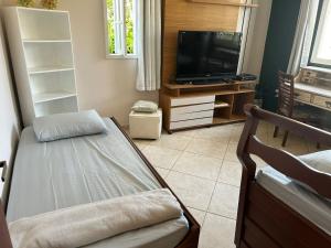 a living room with a bed and a television at Casa de Praia - Long Beach - Cabo Frio - RJ in Tamoios