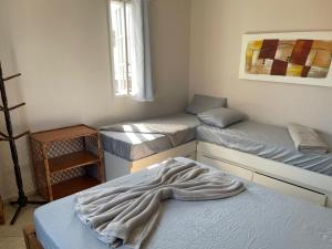 a room with three beds and a blanket on a bed at Casa de Praia - Long Beach - Cabo Frio - RJ in Tamoios +27 photos