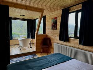 a room with a bed and a tub and a window at Kazbegi Inn Cottages in Kazbegi