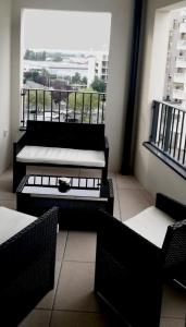 Una habitación con dos camas y sillas y un balcón. en 3 pièces tout neuf de haut standing à 10mn de Paris avec terrasse vue Sacré Coeur, en Asnières-sur-Seine