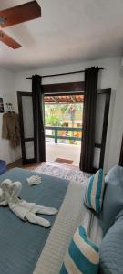a bedroom with a bed with towels and a window at Pousada Cantinho do PÊ Guarujá in Guarujá +191 photos