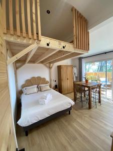 a bedroom with a loft bed and a table at Les Jardins de l'Oustal in Narbonne